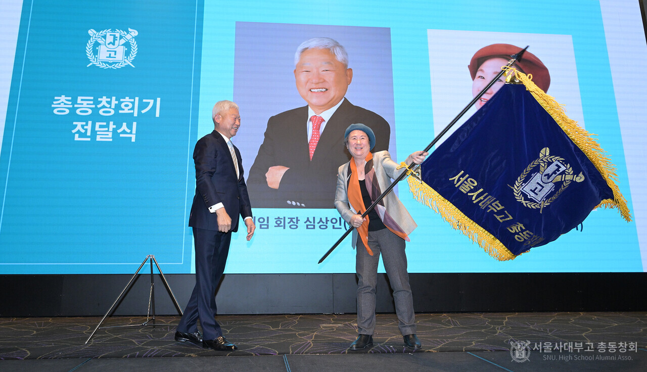 심상인 총동창회장으로부터 총동창회기를 전달 받은 이옥식 신임 회장이 총동창회기를 휘날리고 있다.